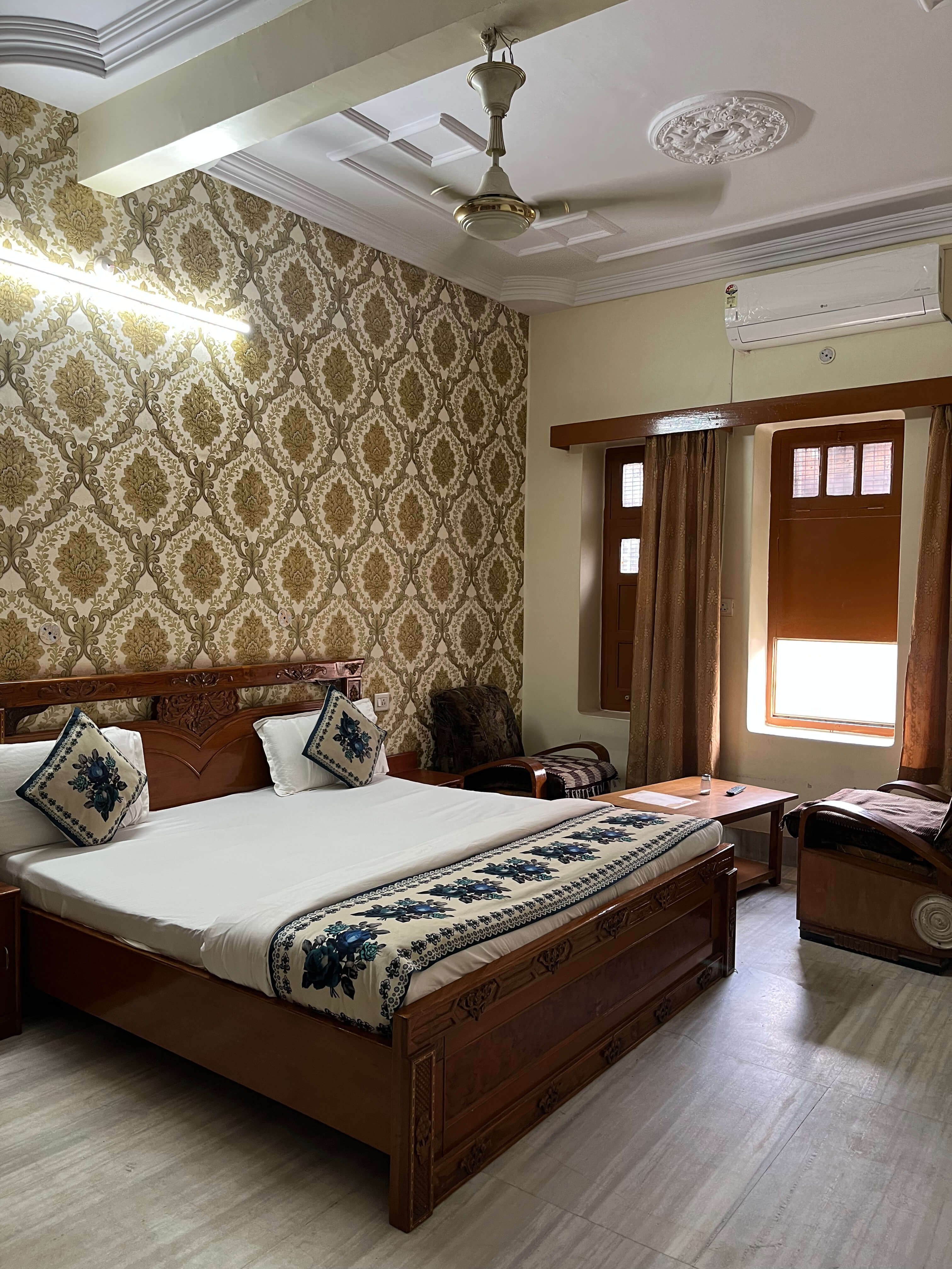Spacious air-conditioned room with a carved wooden bed